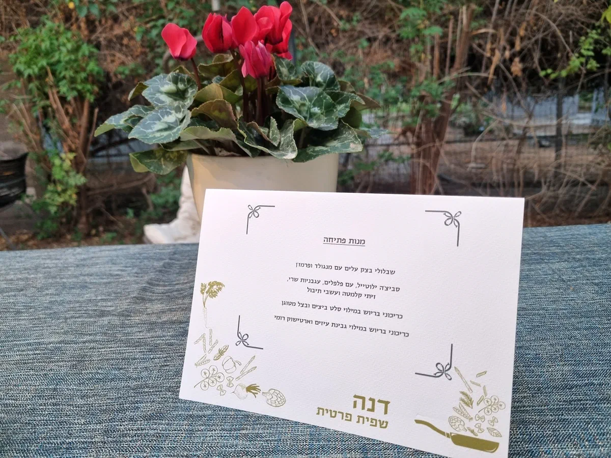 כרטיס תפריט של דנה שפית פרטית על שולחן אירוע בגינה