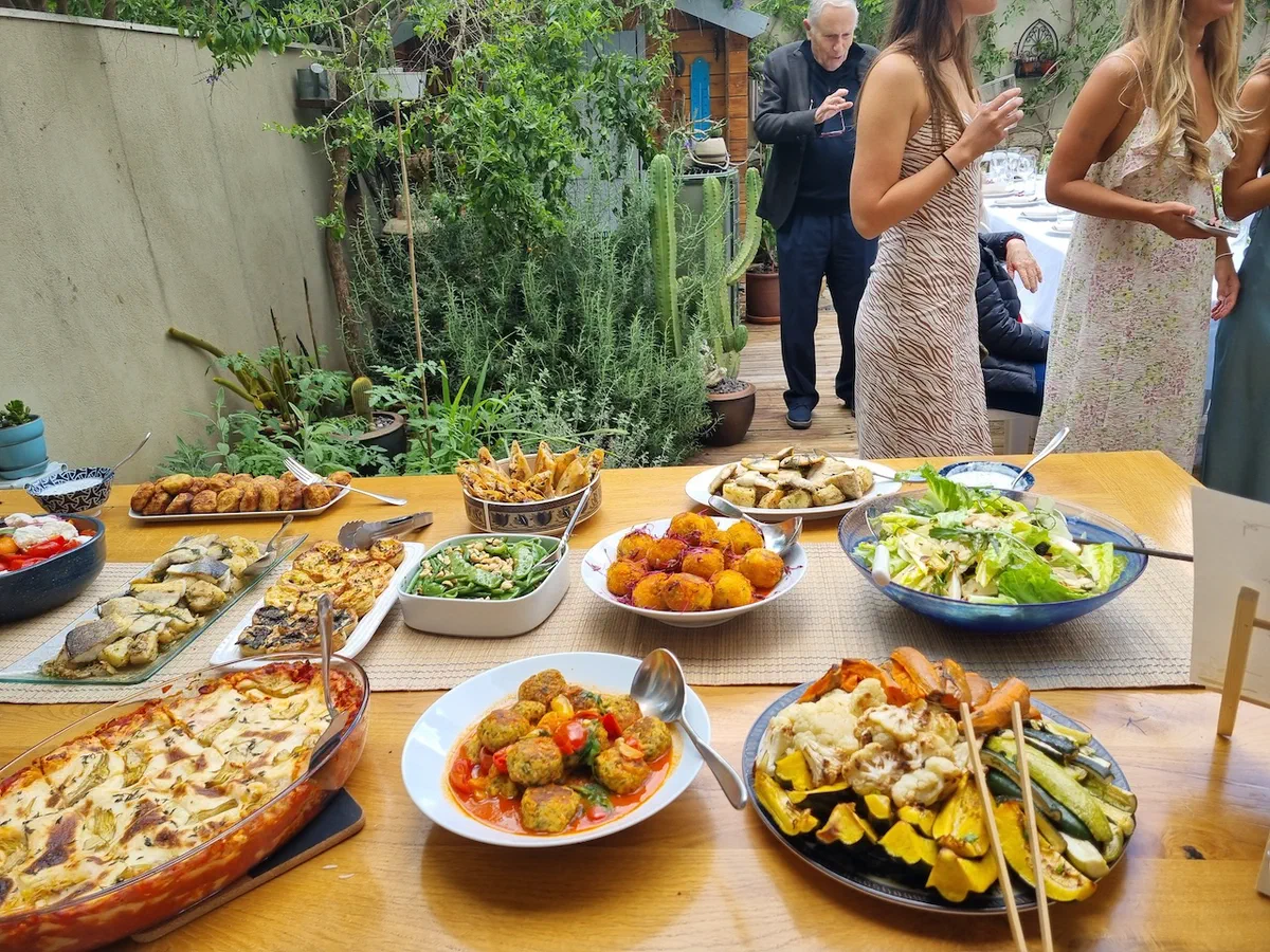 אורחים ליד שולחן הבופה באירוע בגינה
